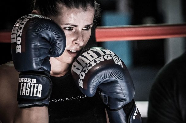 A girl boxing with her heavy bag gloves